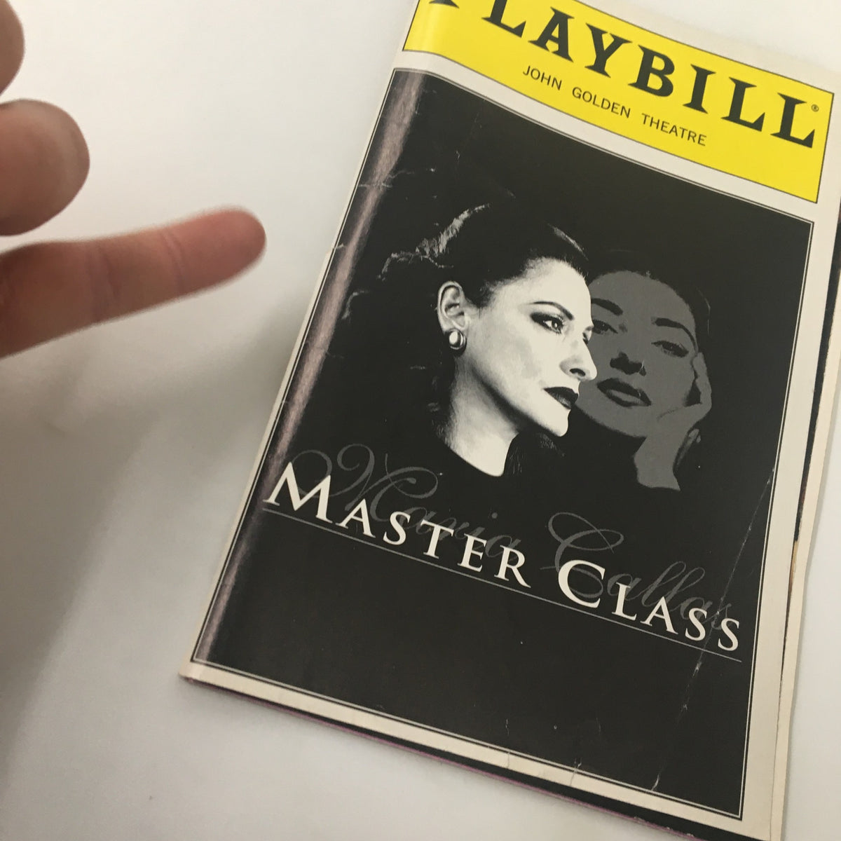 Close-up view of the 1996 Playbill from the Golden Theatre highlighting Patti LuPone in Maria Callas' Master Class, with a hand gesture partially visible.
