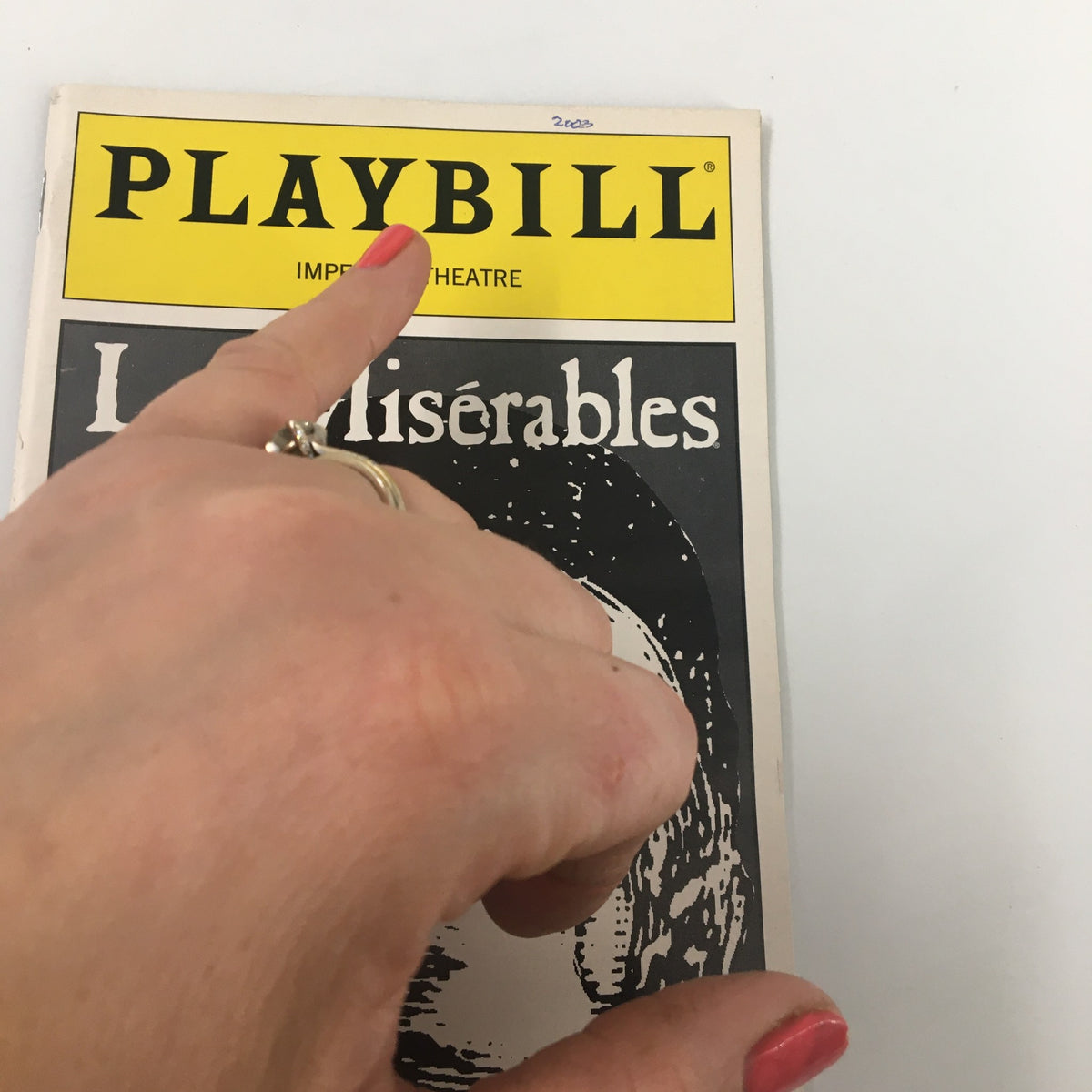 Close-up of the 2003 Playbill for Les Miserables, focusing on the title 'PLAYBILL' and highlighting the cover art.