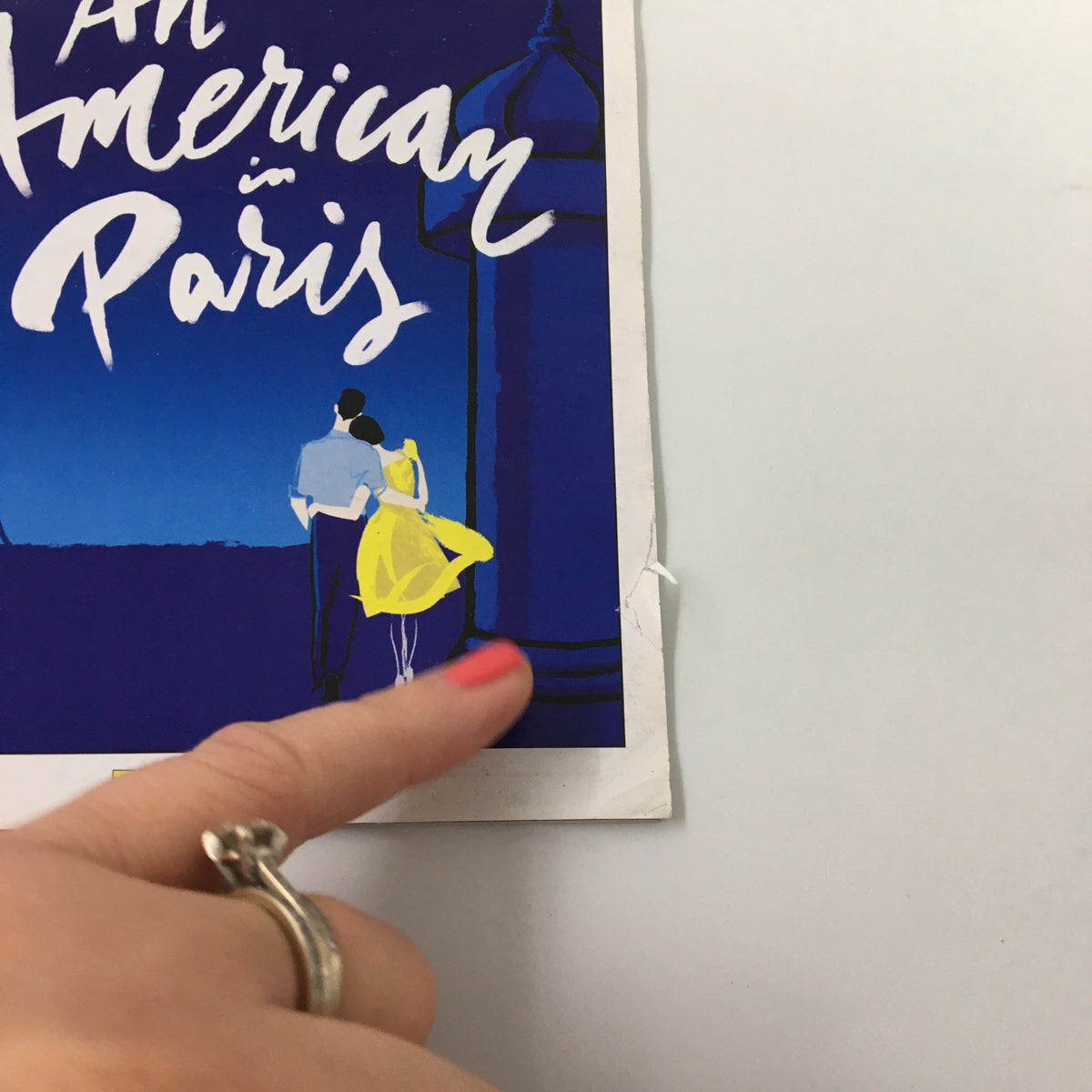 Close-up view of the 2015 Playbill for An American in Paris, highlighting the title and the detail of a hand pointing at the cover.
