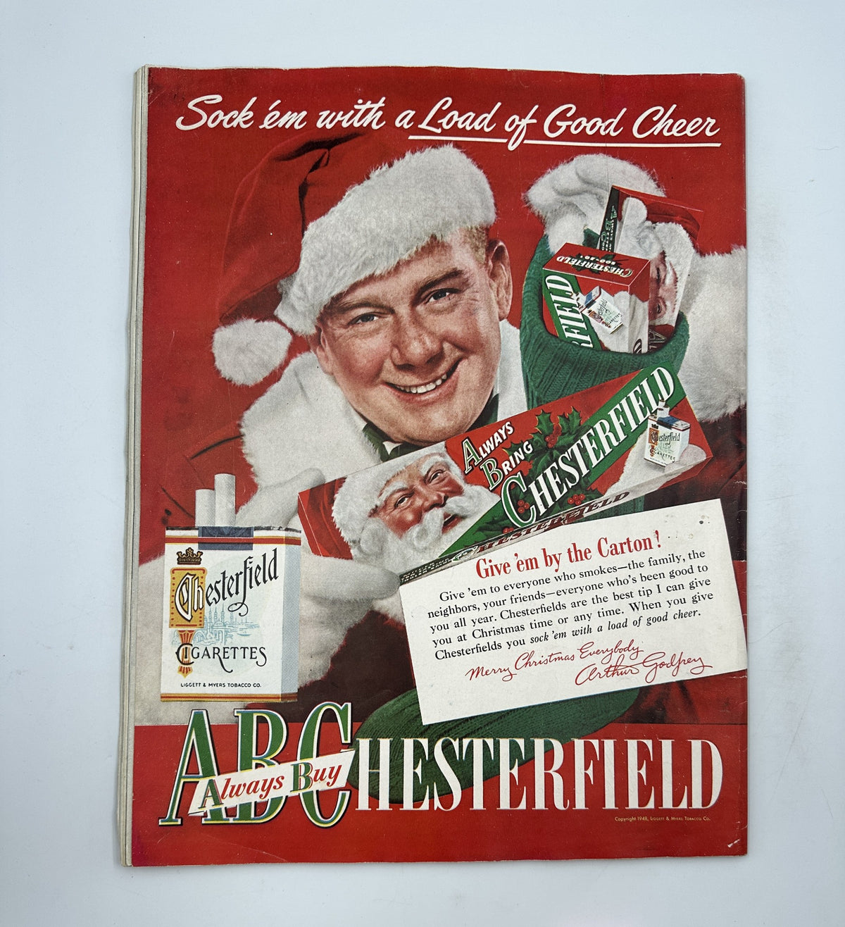 Vintage advertisement cover for Chesterfield cigarettes, showcasing a cheerful Santa Claus and holiday-themed graphics, promoting 'Always Buy Chesterfield'.