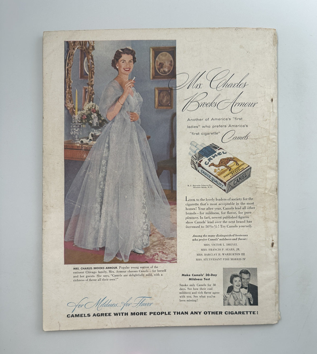 A classic advertisement from Screen Stories Magazine August 1954, showcasing Mrs. Charles Brooks Armour promoting Camel cigarettes, illustrated with a stunning dress and emphasizing elegance and sophistication.