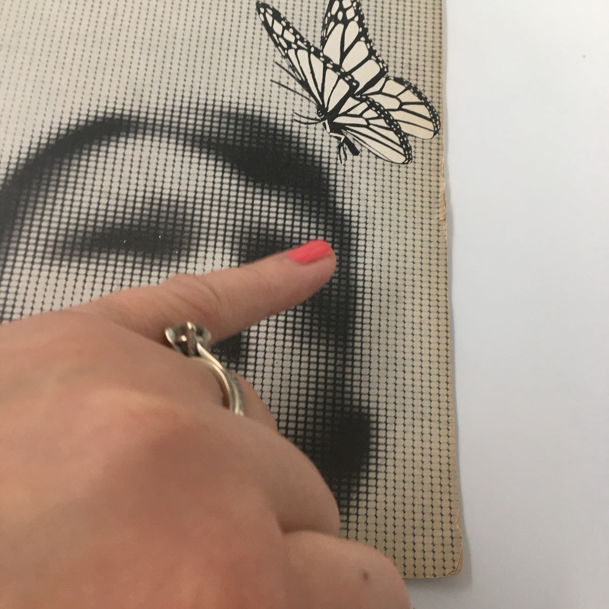 Close-up image of the 1961 Playbill from Belasco Theatre for 'All The Way Home', highlighting a butterfly graphic and a hand pointing at the cover's details.