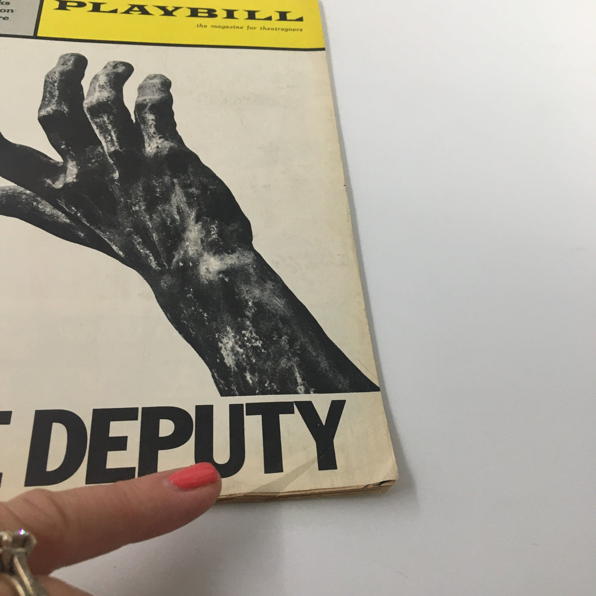 Close-up of the 1964 Playbill for The Deputy at Brooks Atkinson Theatre, highlighting the textured hand design and title.