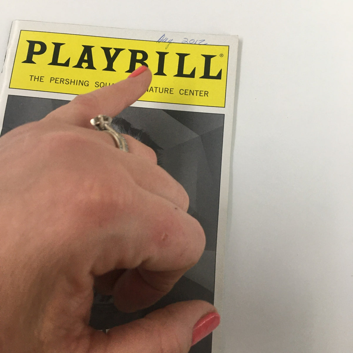 Close-up view of the 2012 Playbill for Heartless by Sam Shepard, showing a hand pointing at the cover with the Pershing Square Signature Center logo.