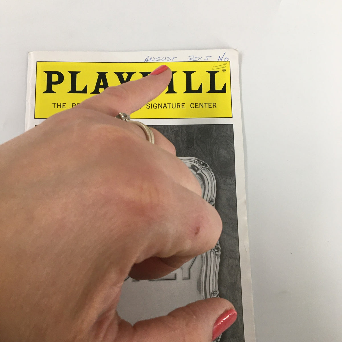 Close-up of the 2015 Playbill for Love & Money, highlighting a handwritten note at the top and a hand pointing at it.
