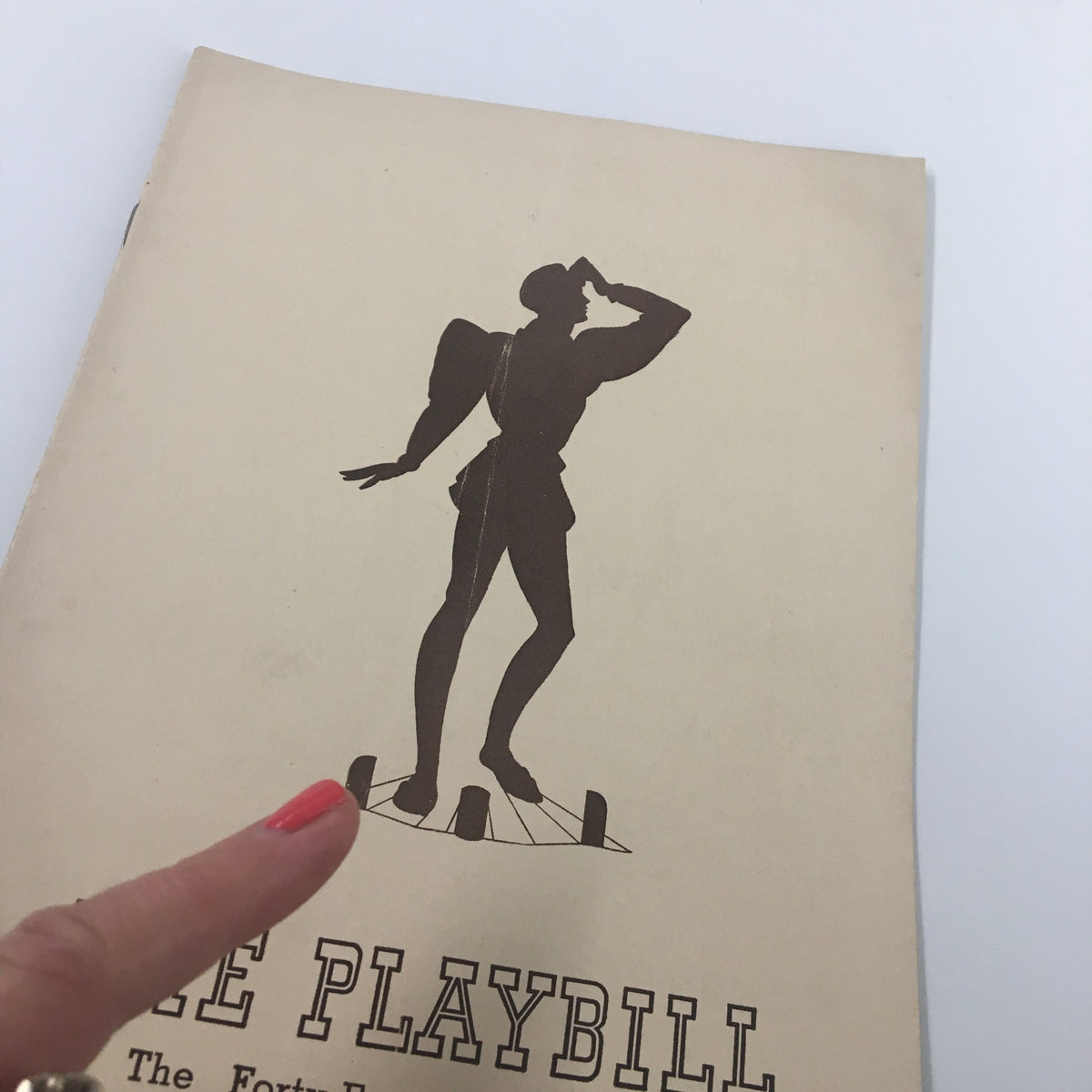 Close-up of the 1939 Playbill for the Forty-Fourth Street Theatre with a pointed finger indicating the silhouette of a performer in Maurice Evans Presents Hamlet.