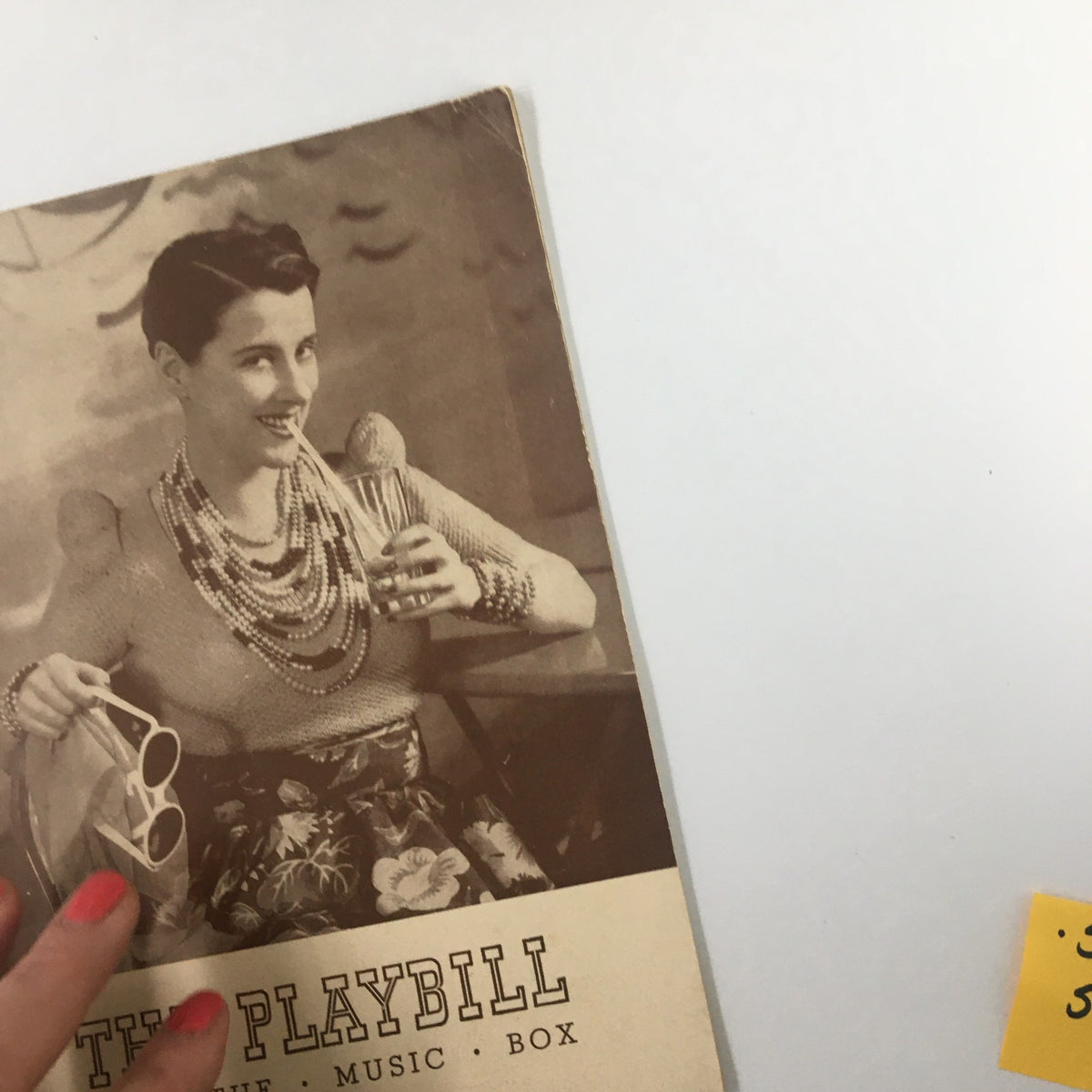1939 Playbill The Music Box featuring Beatrice Lillie, with a woman holding a drink in hand, showcasing vintage fashion and playful decor.