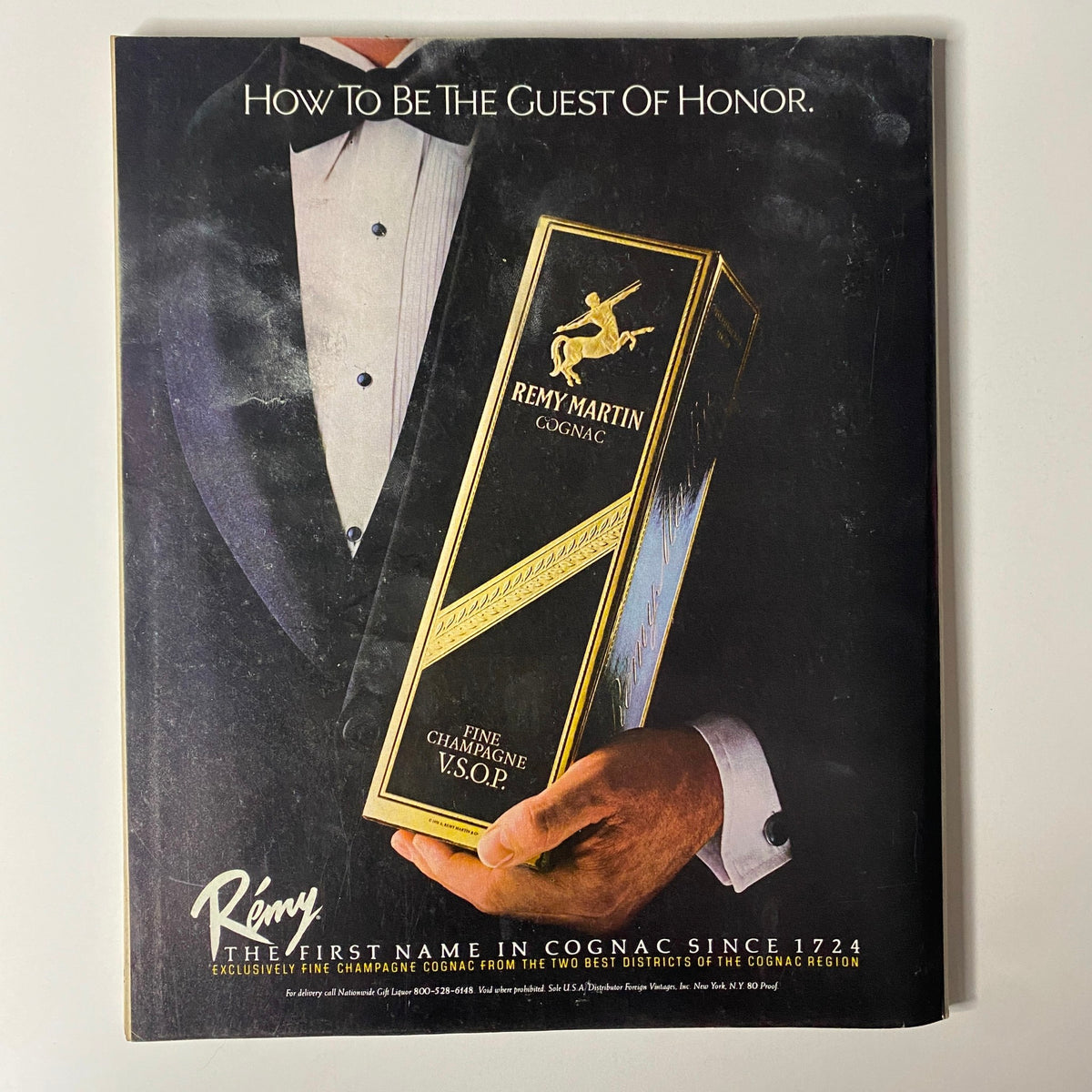 Advertisement featuring Remy Martin Cognac, titled 'How To Be The Guest Of Honor,' showcasing a person in formal attire holding a premium bottle of Remy Martin Fine Champagne V.S.O.P. from Fortune Magazine, dated December 13, 1982.