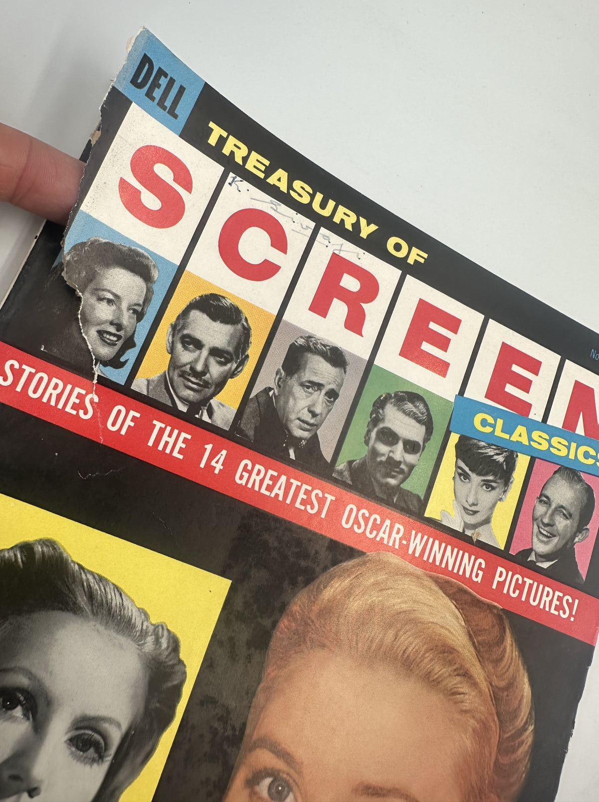 Close-up view of the Treasury of Screen Classics Magazine cover from 1957, highlighting the significant wear, including a torn corner, and prominently featuring Grace Kelly and Greta Garbo.