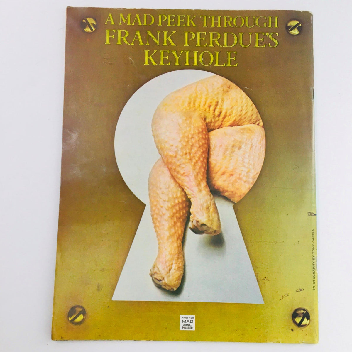 Mad Magazine January 1976 No. 180 Jaws Fine/FN 6.0 featuring a humorous cover illustration titled 'A Mad Peek Through Frank Perdue's Keyhole', showcasing a creative and comedic representation of chicken legs through a keyhole.
