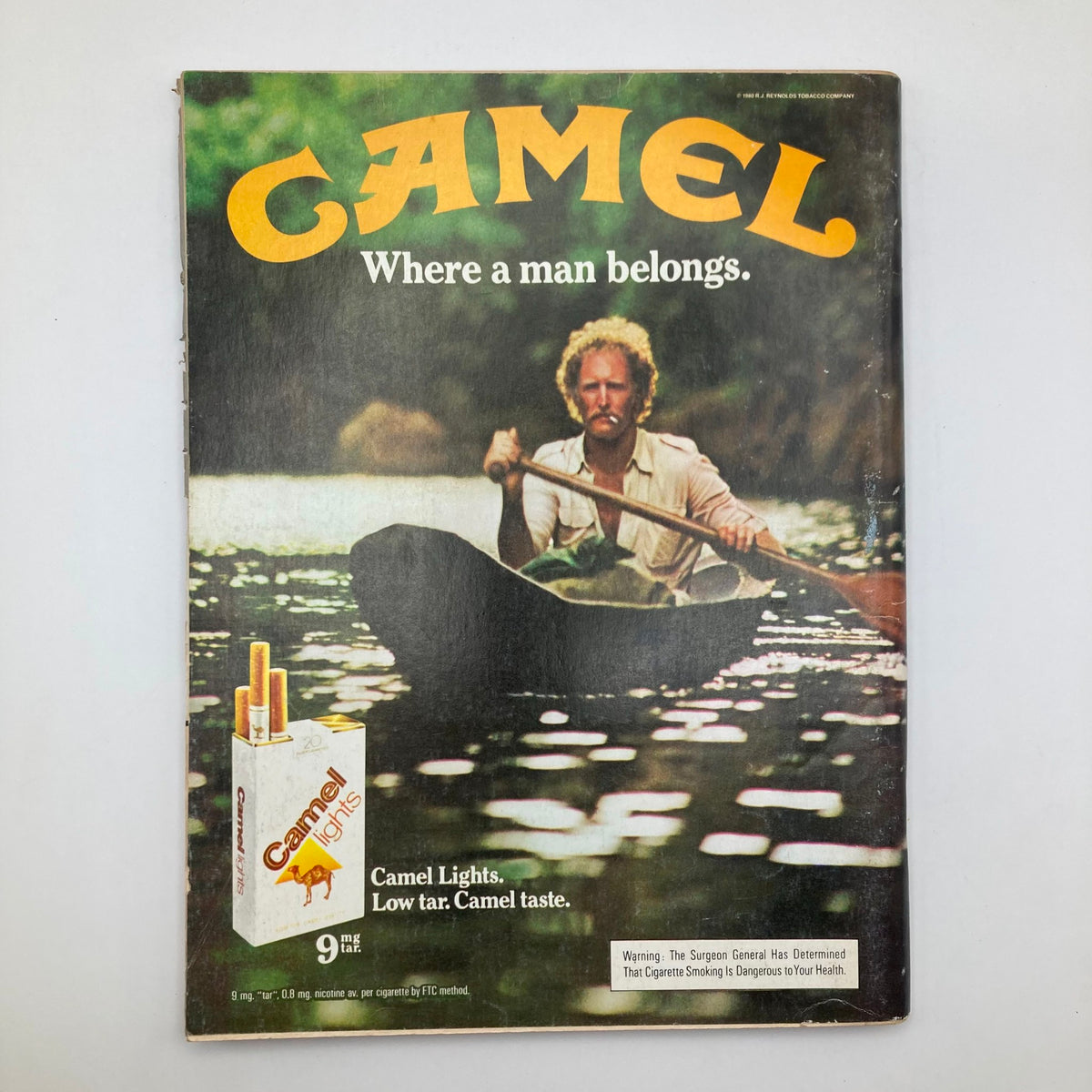 Ad page from the VTG Playboy Magazine February 1981 depicting a vintage Camel cigarette advertisement with a man in a canoe, highlighting classic advertising style.