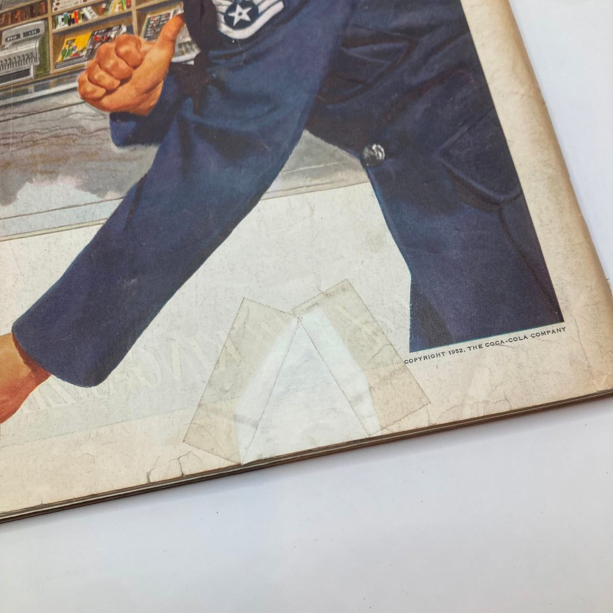 Close-up of the Coca-Cola ad on the cover of Saturday Evening Post Magazine February 23, 1952, highlighting the vintage artwork and details of the military man's uniform.
