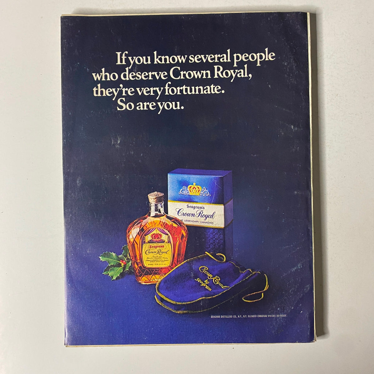 Esquire Magazine December 1977 Cover featuring an advertisement for Crown Royal whiskey, showcasing a bottle, box, and bag with the tagline discussing the value of sharing with fortunate individuals.