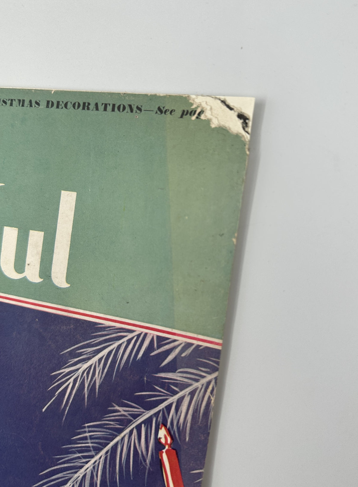 Close-up of the December 1932 House Beautiful Magazine cover with Christmas decorations, featuring a tear on the edge. The magazine presents design inspiration for the festive season.