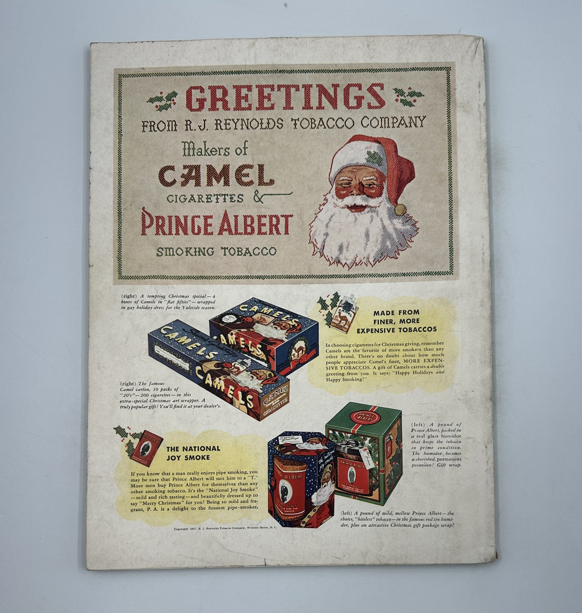 Cover of House Beautiful Magazine December 1937 featuring a festive greeting from R.J. Reynolds Tobacco Company, showcasing Christmas-themed cigarette packaging by Camel and Prince Albert.