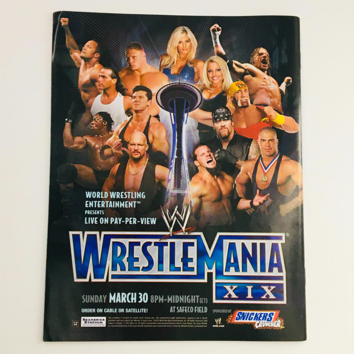 Promotional poster for WWE WrestleMania XIX featuring a collage of wrestling stars and event details, capturing the excitement of live pay-per-view entertainment.