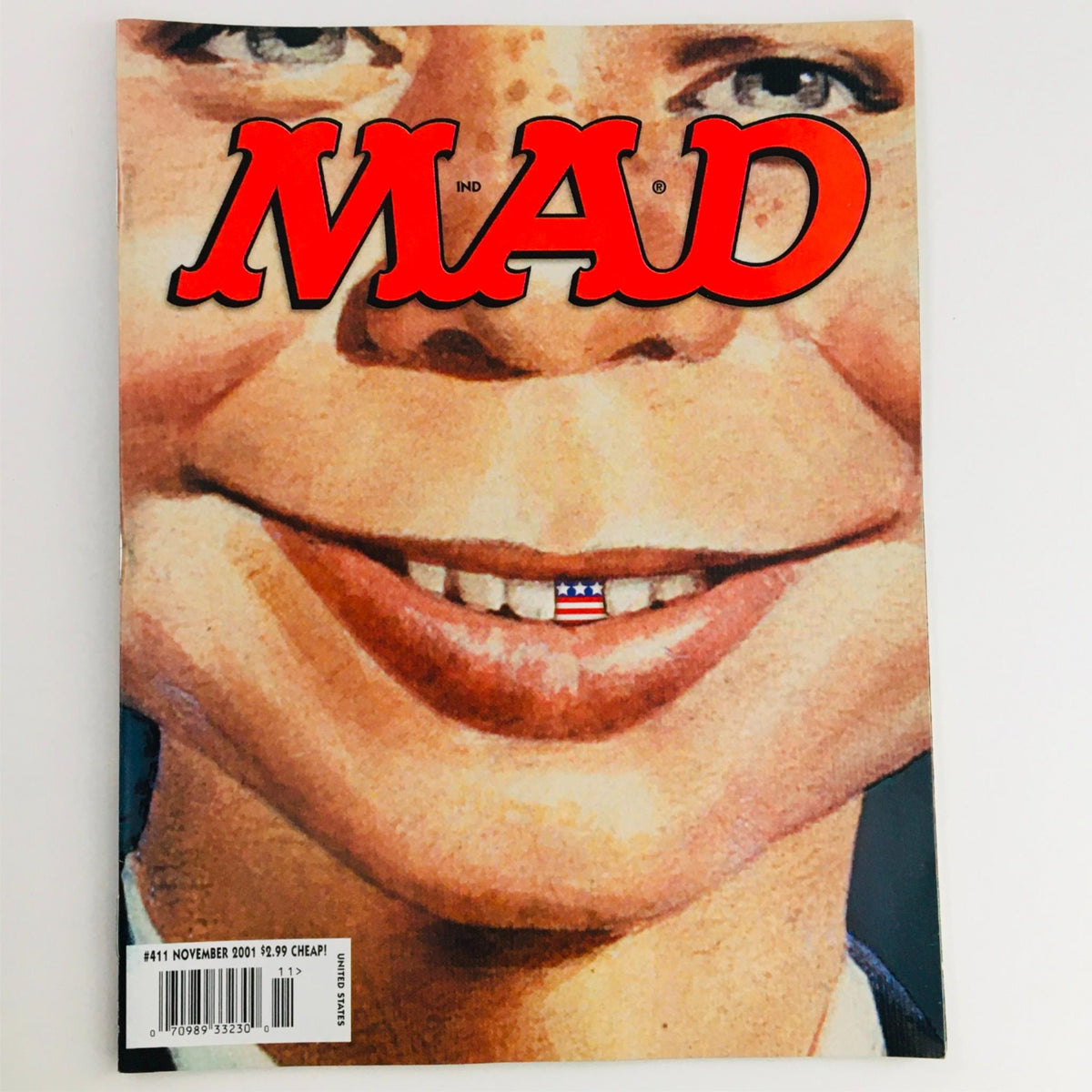 Mad Magazine November 2001 No. 411 cover featuring Alfred E. Neuman with an American flag tooth, showcasing a humorous and satirical style indicative of the magazine's legacy.