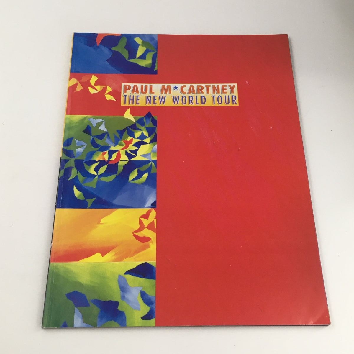 Cover of Paul McCartney The New World Tour 1993 brochure featuring colorful abstract design.