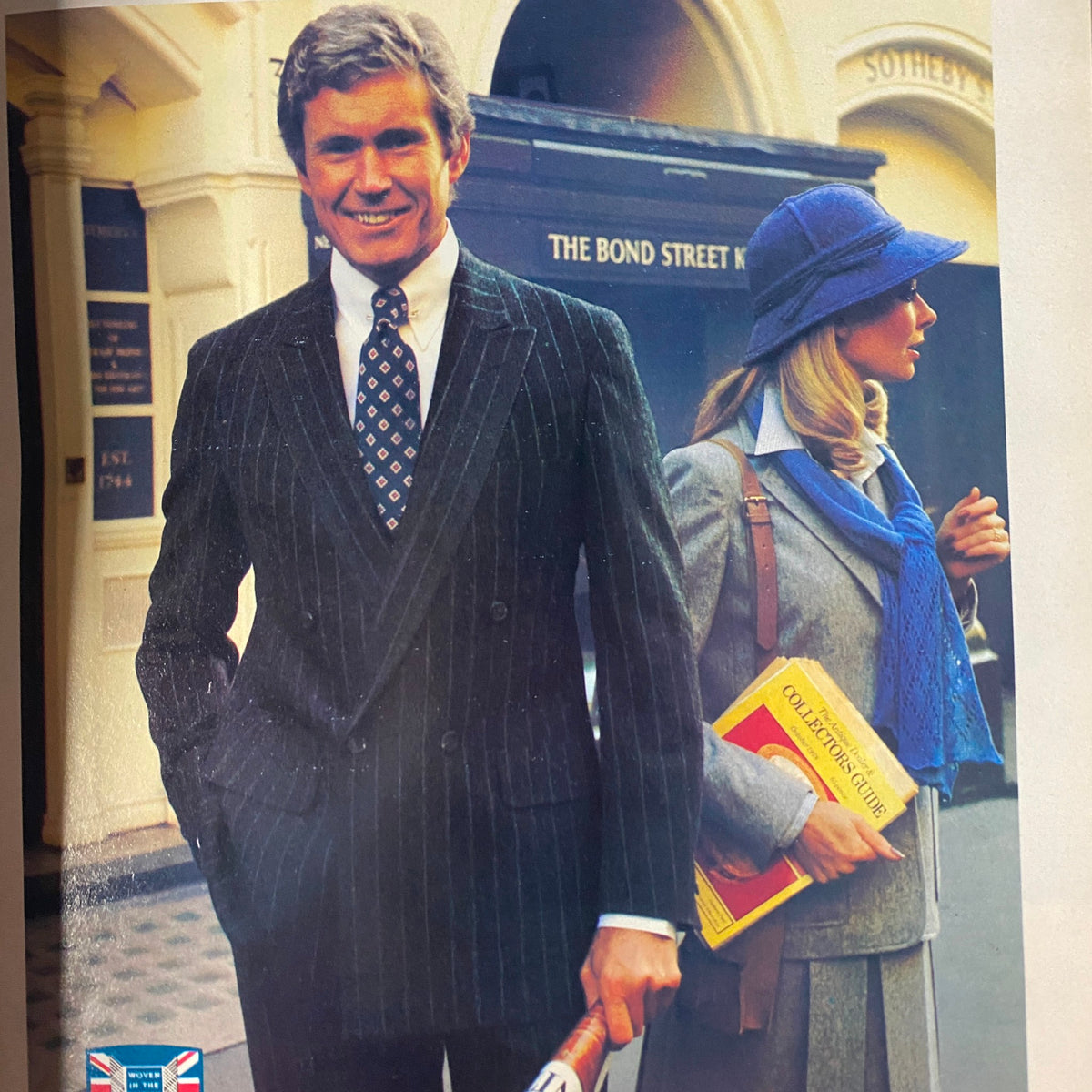 Fashionable couple in the late 1970s, featured in The New Yorker magazine, September 17, 1979. The man is dressed in a pinstriped suit and tie, while the woman wears a stylish outfit complete with a hat and scarf, capturing the era's cultural trends. The New Yorker magazine is adorned with a Jean-Jacques Sempé cover.