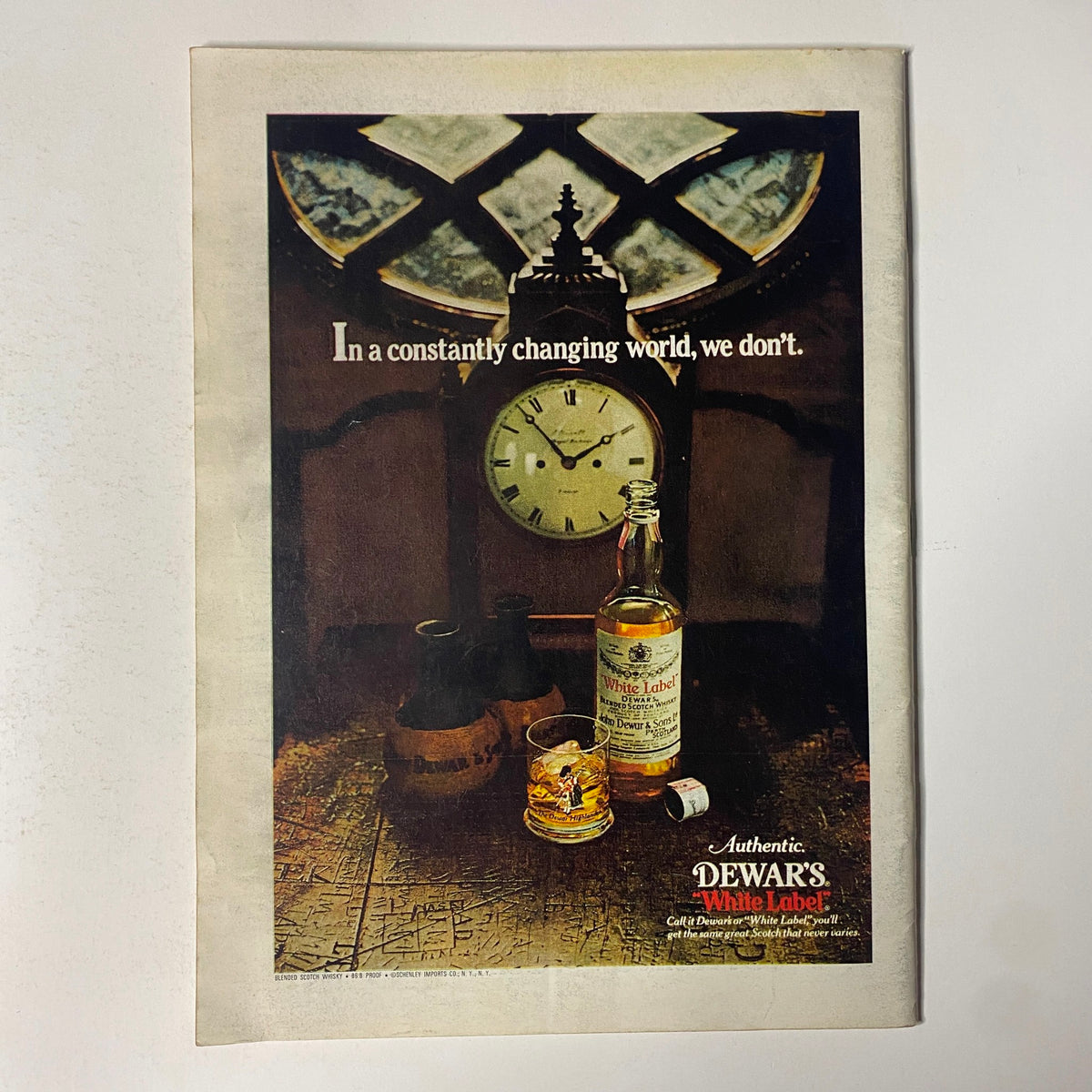 Vintage advertisement for Dewar's White Label featured in The New Yorker Full Magazine July 18, 1977, showcasing a bottle of whisky alongside a clock and glass.