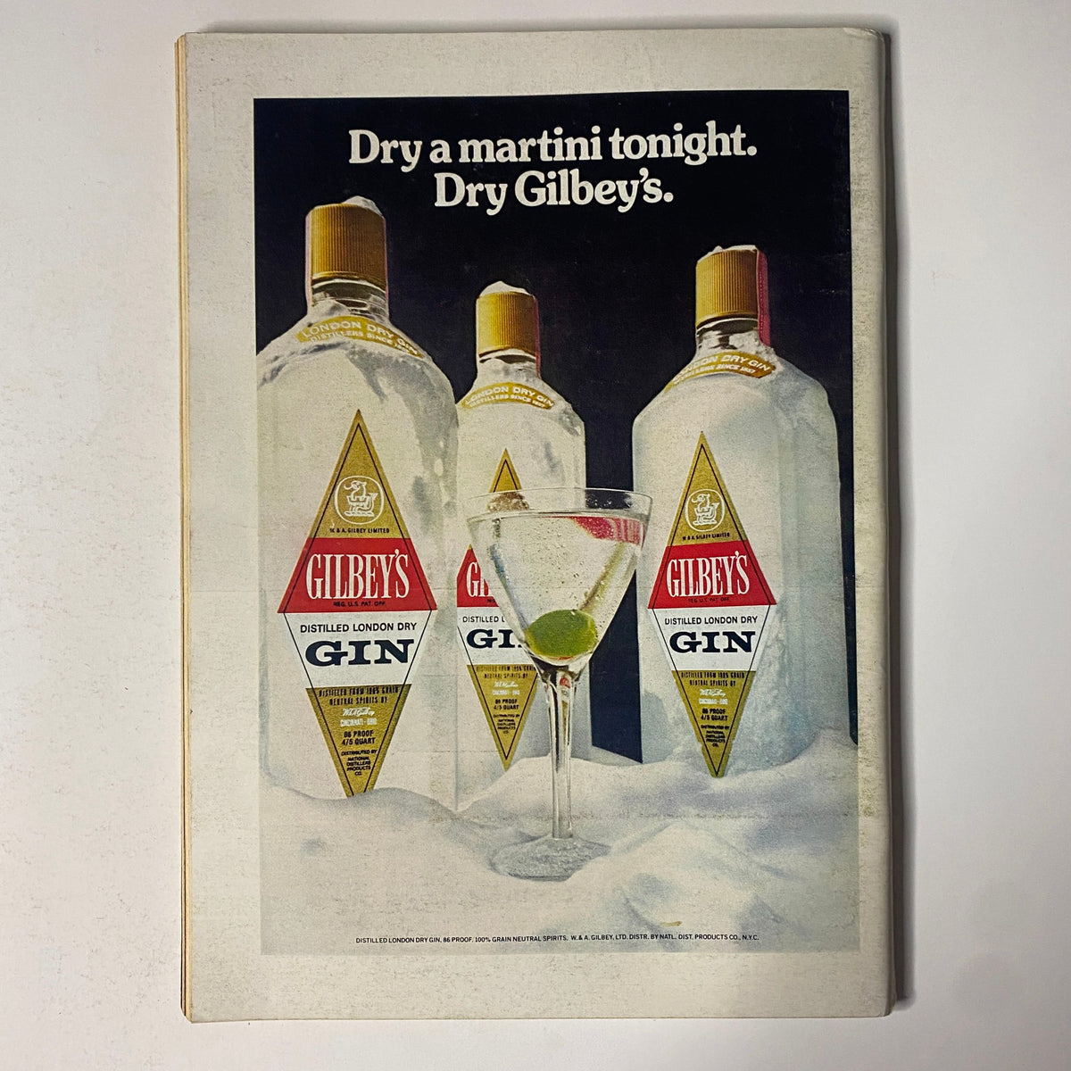 Advertisement from The New Yorker magazine, October 7, 1974, showcasing three bottles of Gilbey's gin with a martini glass, promoting the message 'Dry a martini tonight. Dry Gilbey's.' Vintage advertising design.
