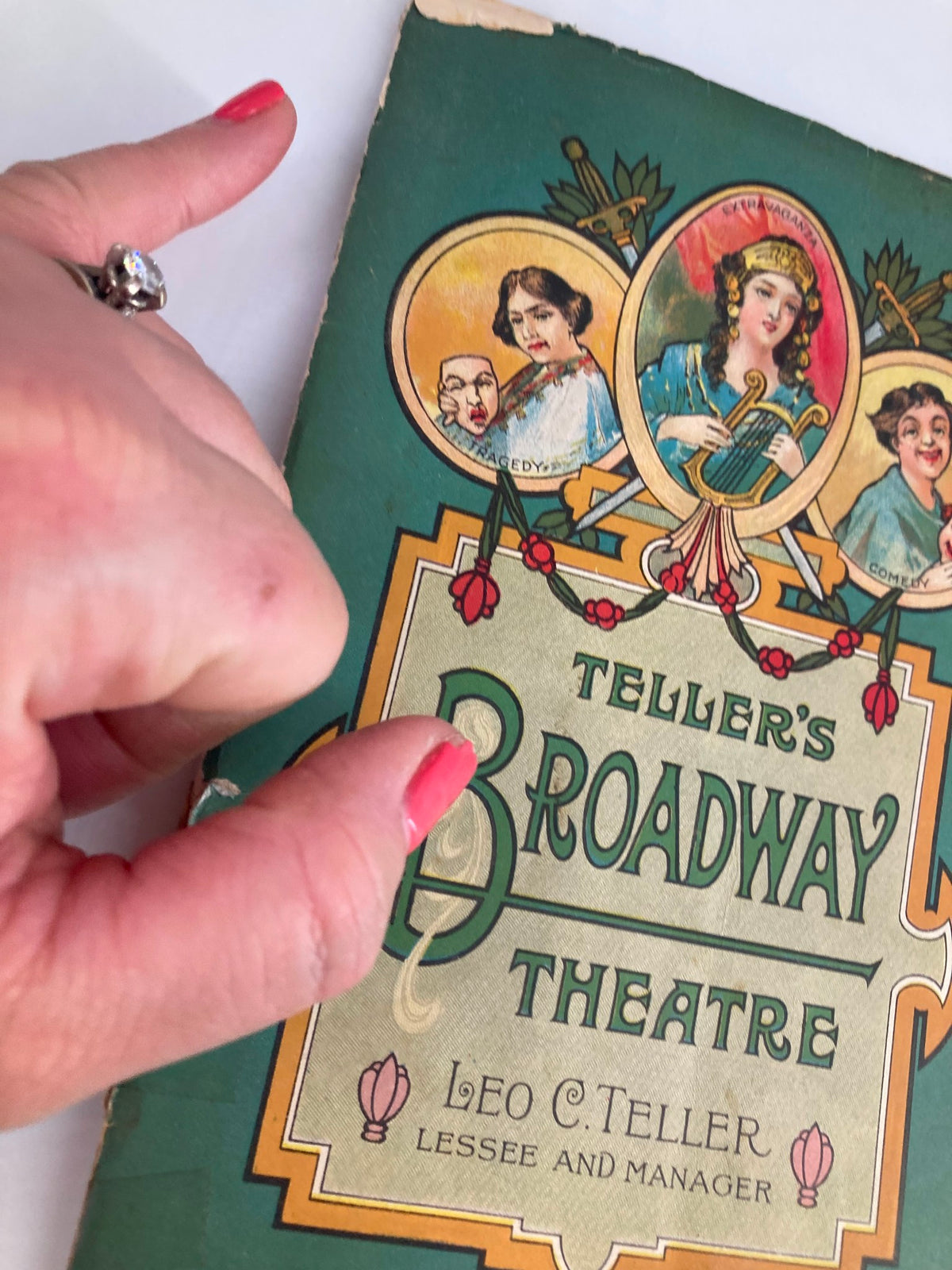 Close-up view of the 1916 Teller's Broadway Theatre Playbill cover held by a hand, highlighting the vintage design and details of The Spring Maid.