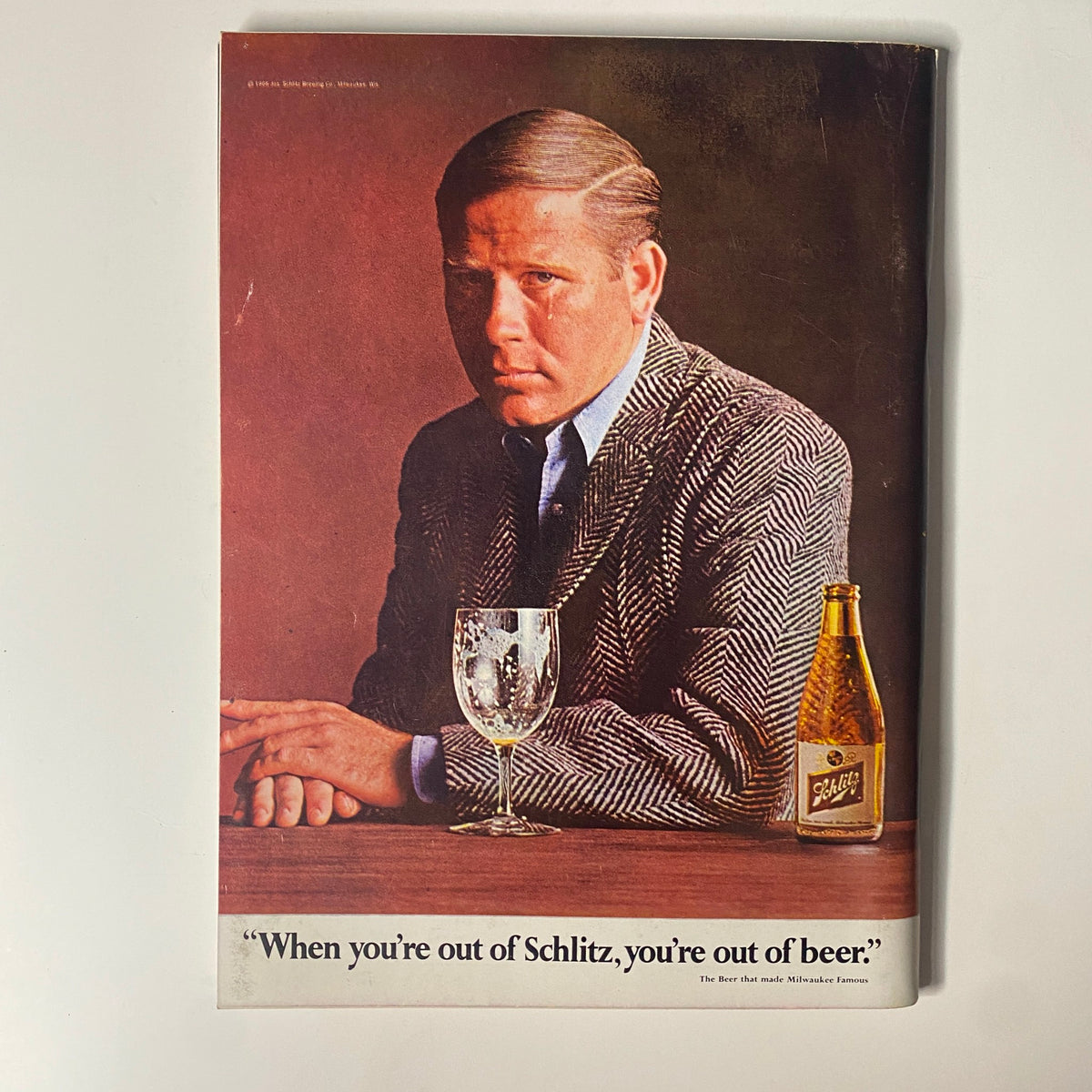 Back cover of Playboy Magazine January 1968 featuring an advertisement with a serious man sitting at a table. The tagline reads, 'When you’re out of Schlitz, you’re out of beer,' showcasing retro advertising style.