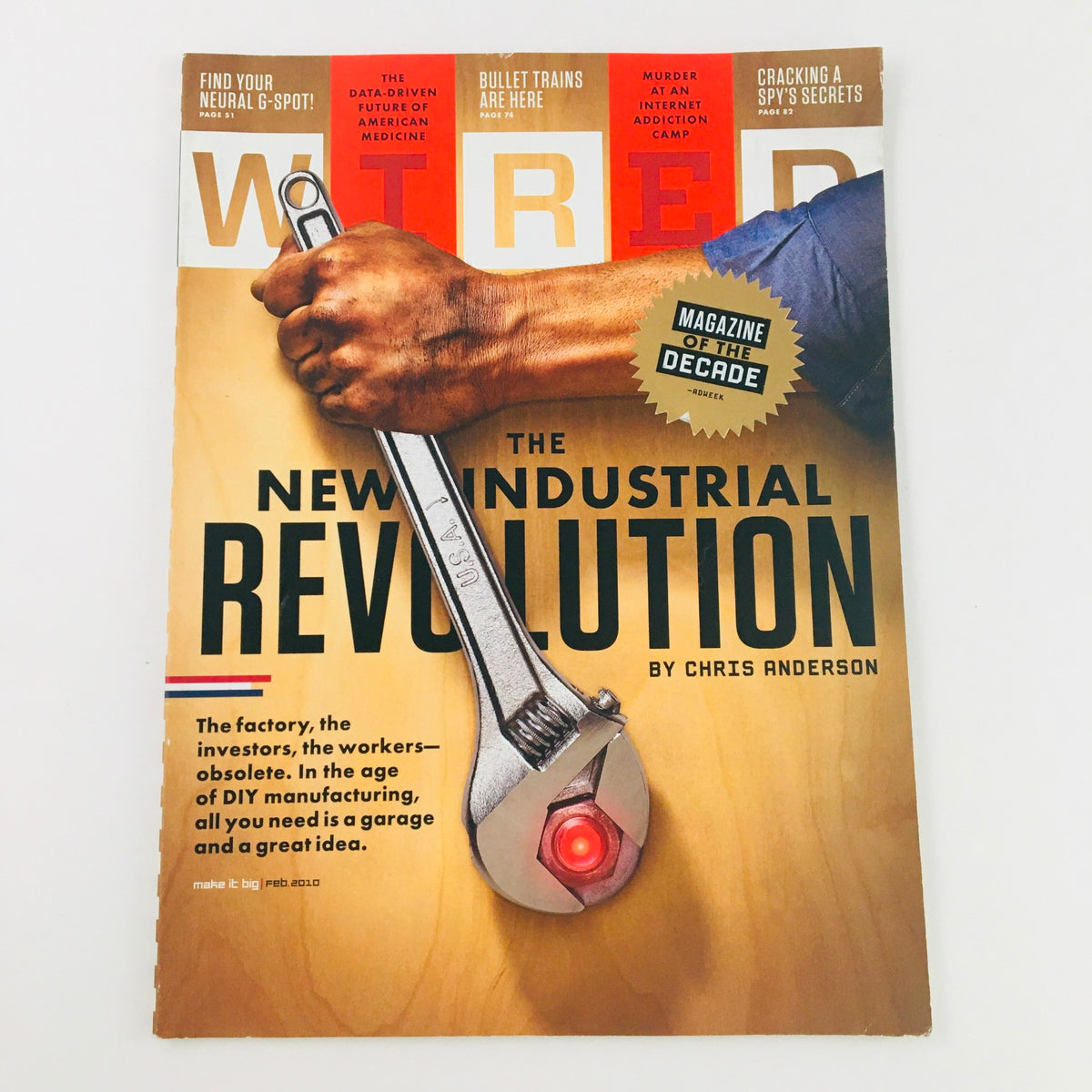 Wired Magazine February 2010 cover featuring 'The New Industrial Revolution' by Chris Anderson, showcasing a hand gripping a large wrench, symbolizing the transformation in industry and DIY culture.