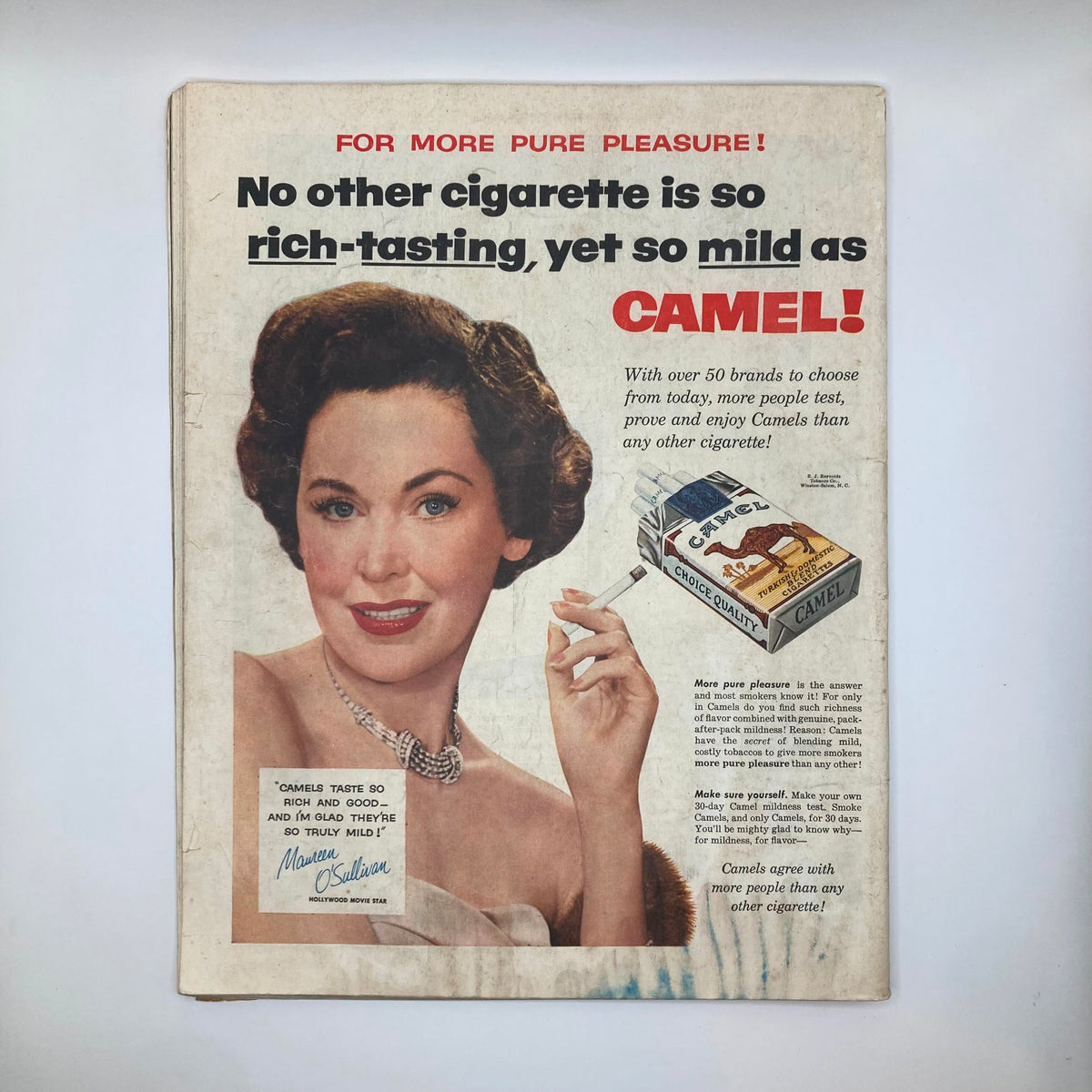 Back cover of the November 13, 1954 Saturday Evening Post Magazine featuring a vintage advertisement for Camel cigarettes, showcasing a fashionable woman with a cigarette.