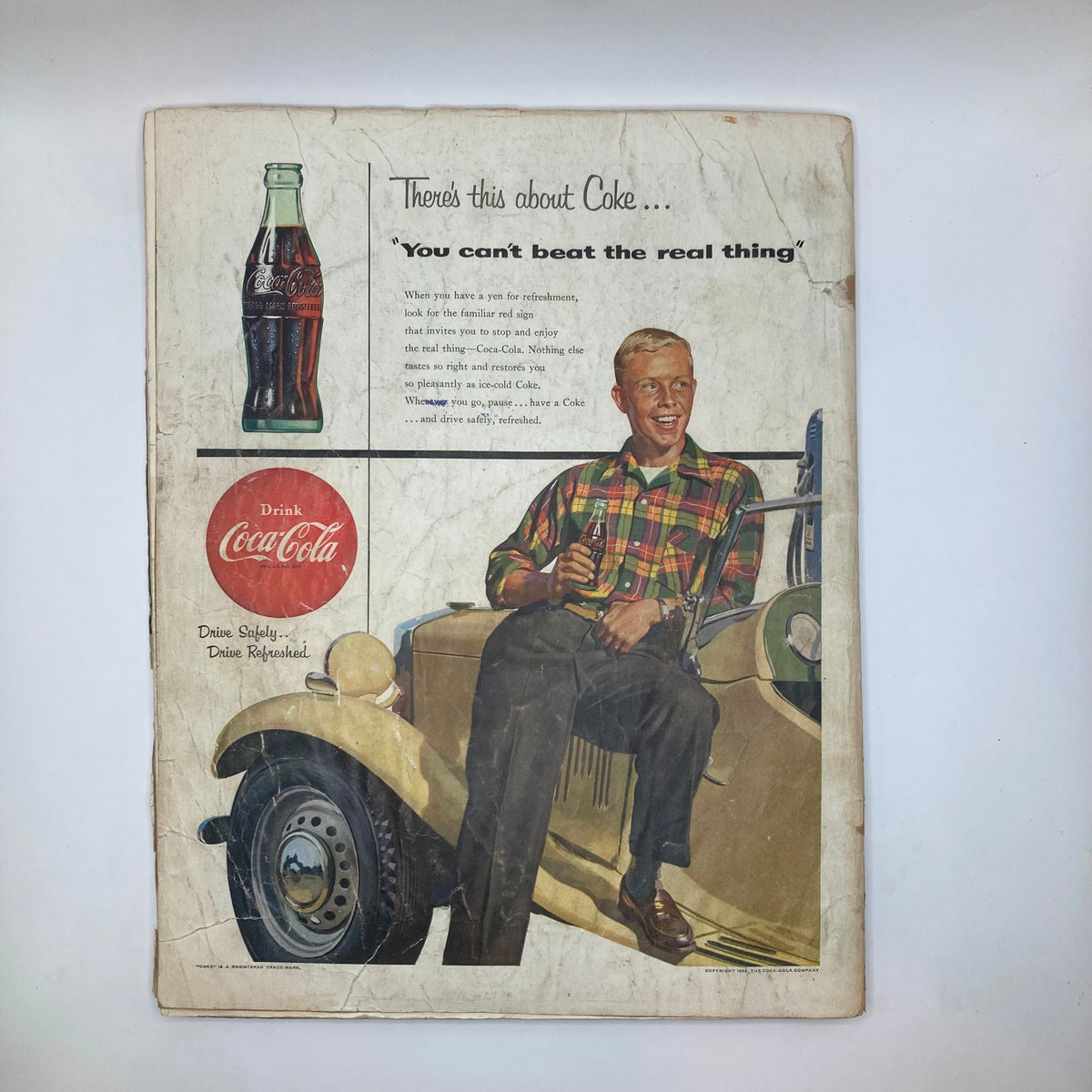 Back cover of Saturday Evening Post Magazine, June 12, 1954. An advertisement for Coca-Cola featuring a young man in a checkered shirt, emphasizing Americana and mid-20th century advertising aesthetics.