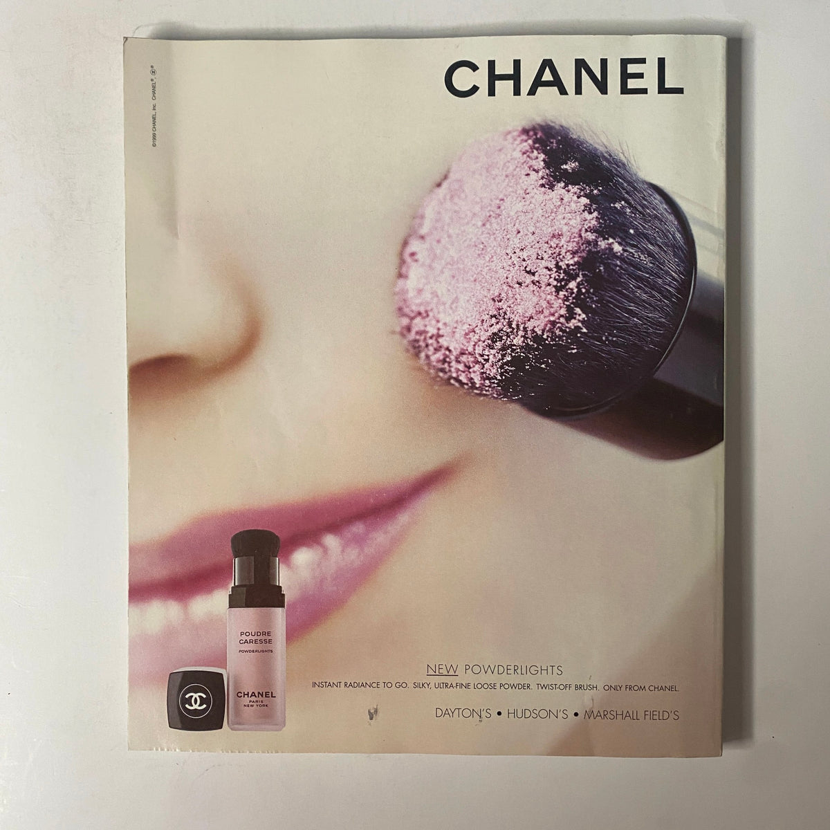 Chanel advertisement for New Powderlights featuring a makeup brush and powder product.