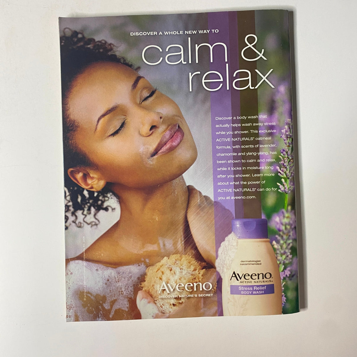 Advertisement for Aveeno Stress Relief Body Wash from Essence Magazine September 2008 featuring a woman enjoying a relaxing shower, promoting calm and relaxation with lavender and chamomile.