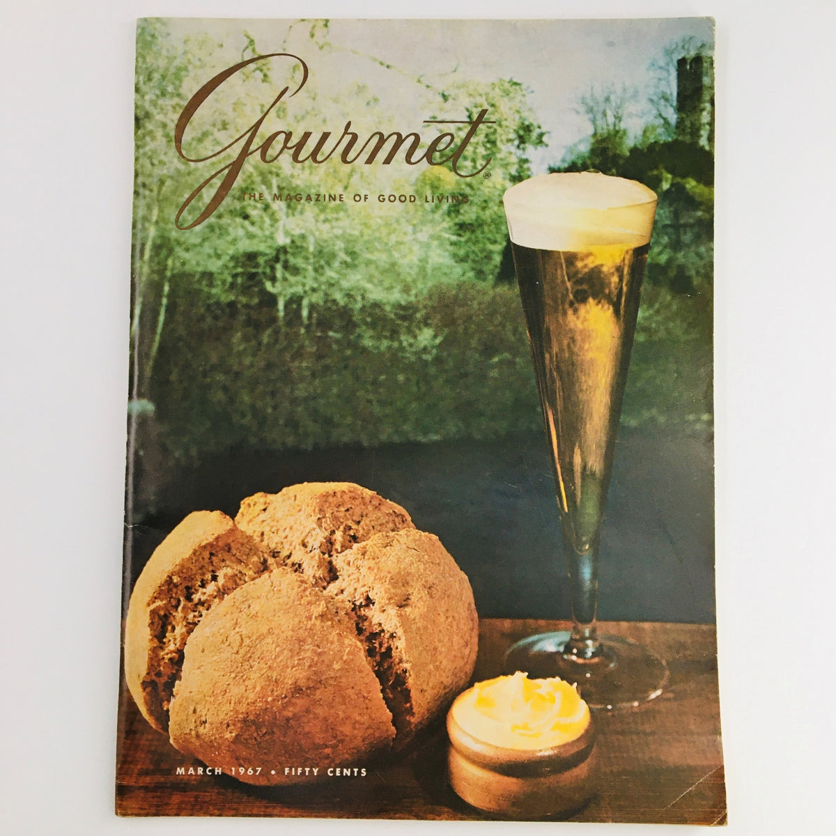Cover of Gourmet Magazine of Good Living from March 1967 featuring a rustic bread loaf, a butter pat, and a glass of beer, themed around Easter feasts.