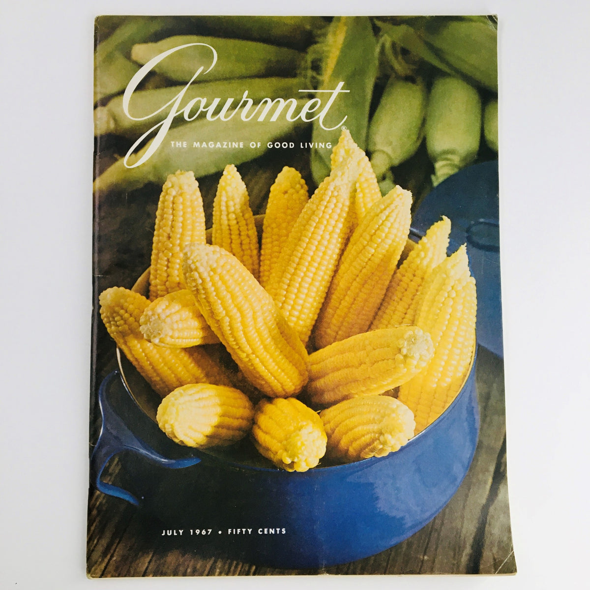 Gourmet Magazine of Good Living July 1967 featuring a vibrant cover with fresh yellow corn in a blue pot, showcasing seasonal recipes and culinary nostalgia.