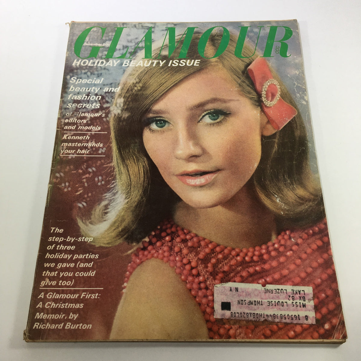 Cover of VTG Glamour Magazine: December 1964 - Holiday Beauty Issue featuring a model with styled hair and a festive red outfit, showcasing mid-20th century beauty and fashion.