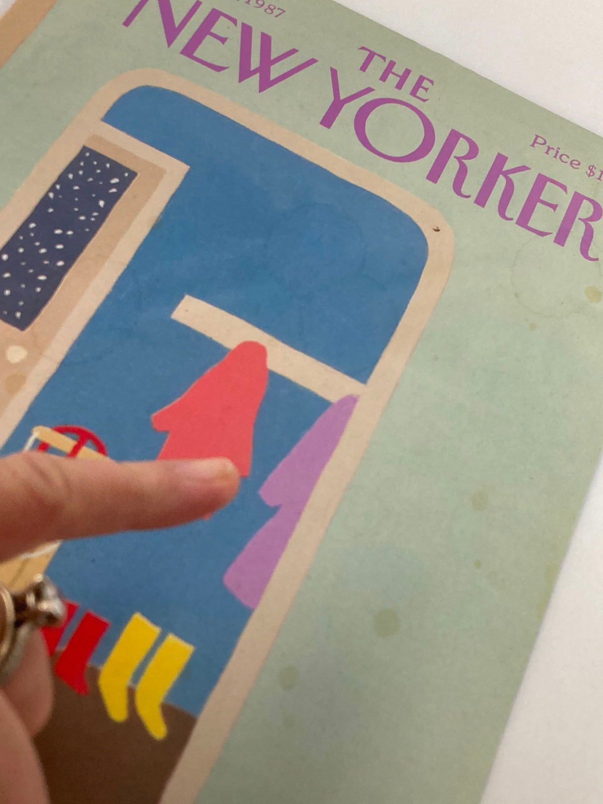 Detailed image of The New Yorker March 16, 1987 cover, with a finger pointing at the raincoat illustration, highlighting the artistic style of Heidi Goennel.