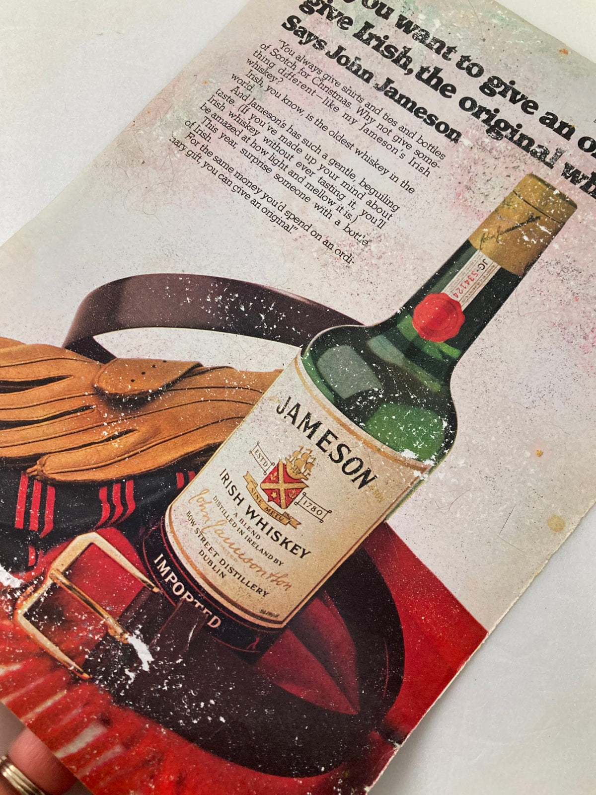 Vintage advertisement for Jameson Irish Whiskey from The New Yorker, featuring a whiskey bottle and accessories with a textured background.