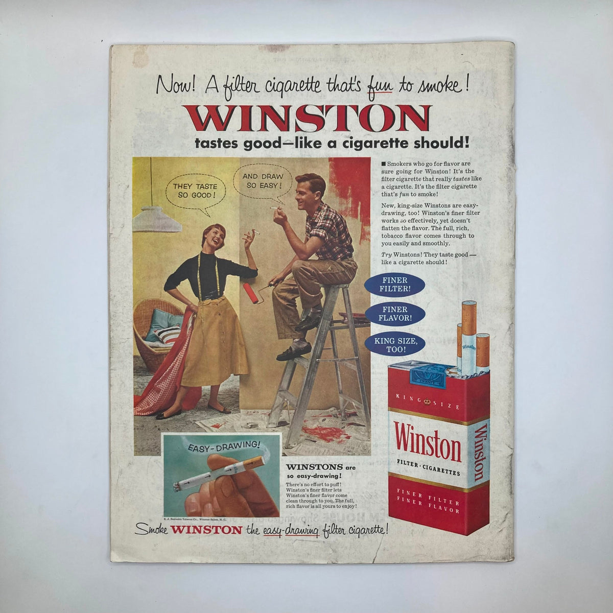 Winston Cigarettes advertisement from Saturday Evening Post Magazine February 26 1955, featuring a cheerful illustration of a woman and a man painting, promoting filter cigarettes that taste good.