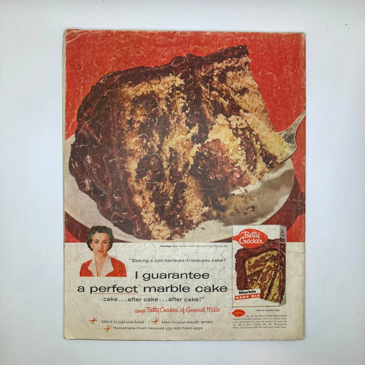 Cover of Betty Crocker advertisement featuring a delicious marble cake, stating 'I guarantee a perfect marble cake', presented in vibrant red background, from the July 14 1956 issue of Saturday Evening Post Magazine.
