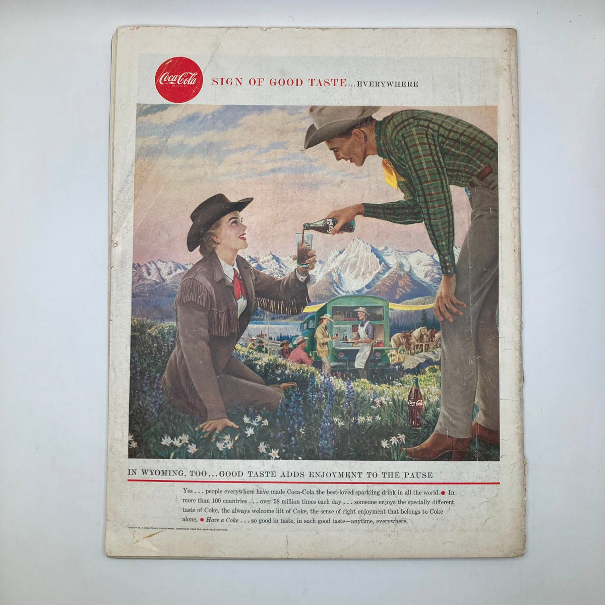 Back cover of Saturday Evening Post Magazine May 10 1958 with an advertisement for Coca-Cola, depicting a couple enjoying drinks in a scenic outdoor setting.