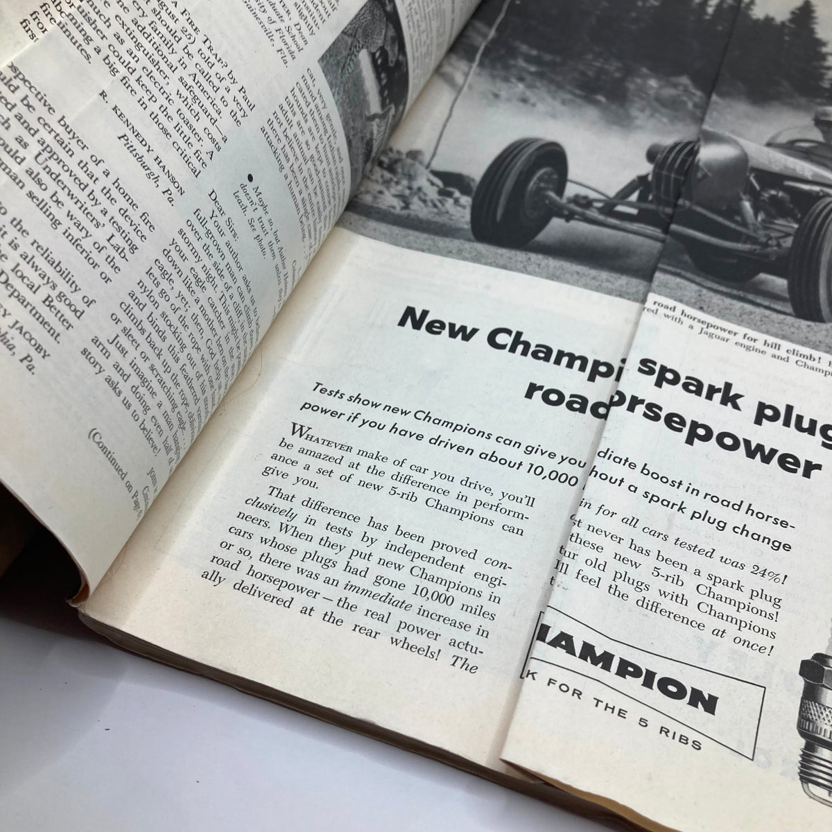 Interior page of the September 29, 1956 Saturday Evening Post magazine showcasing an advertisement for Champion spark plugs highlighting their performance benefits.