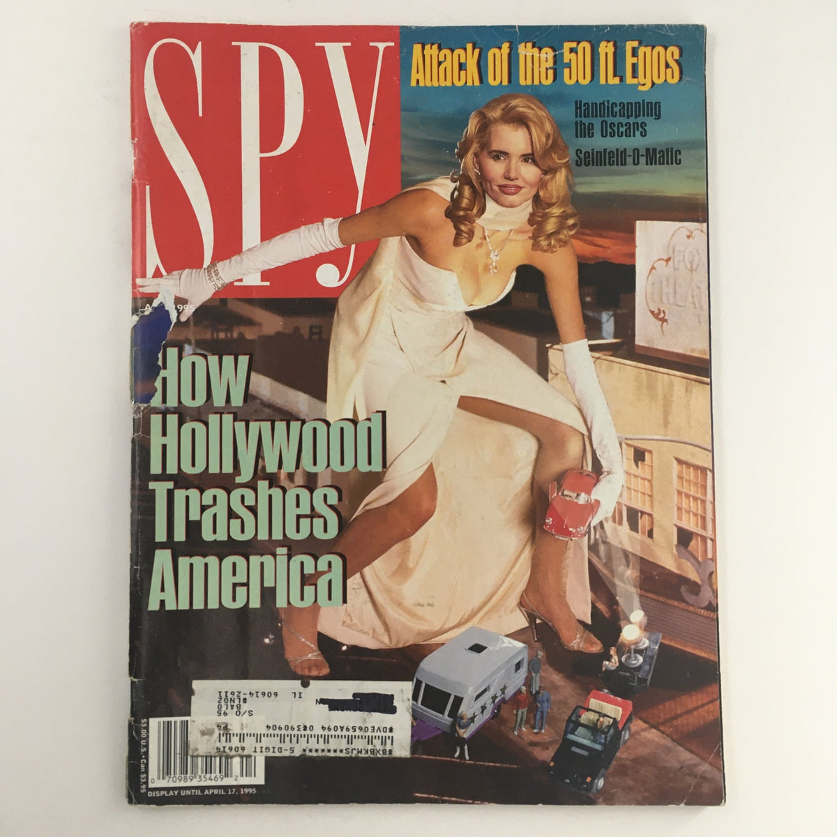 April 1995 issue of Spy Magazine featuring the cover story 'How Hollywood Trashes America'. The cover showcases a model in elegant attire with a playful pose in an urban setting, highlighting the magazine's satirical take on Hollywood culture.