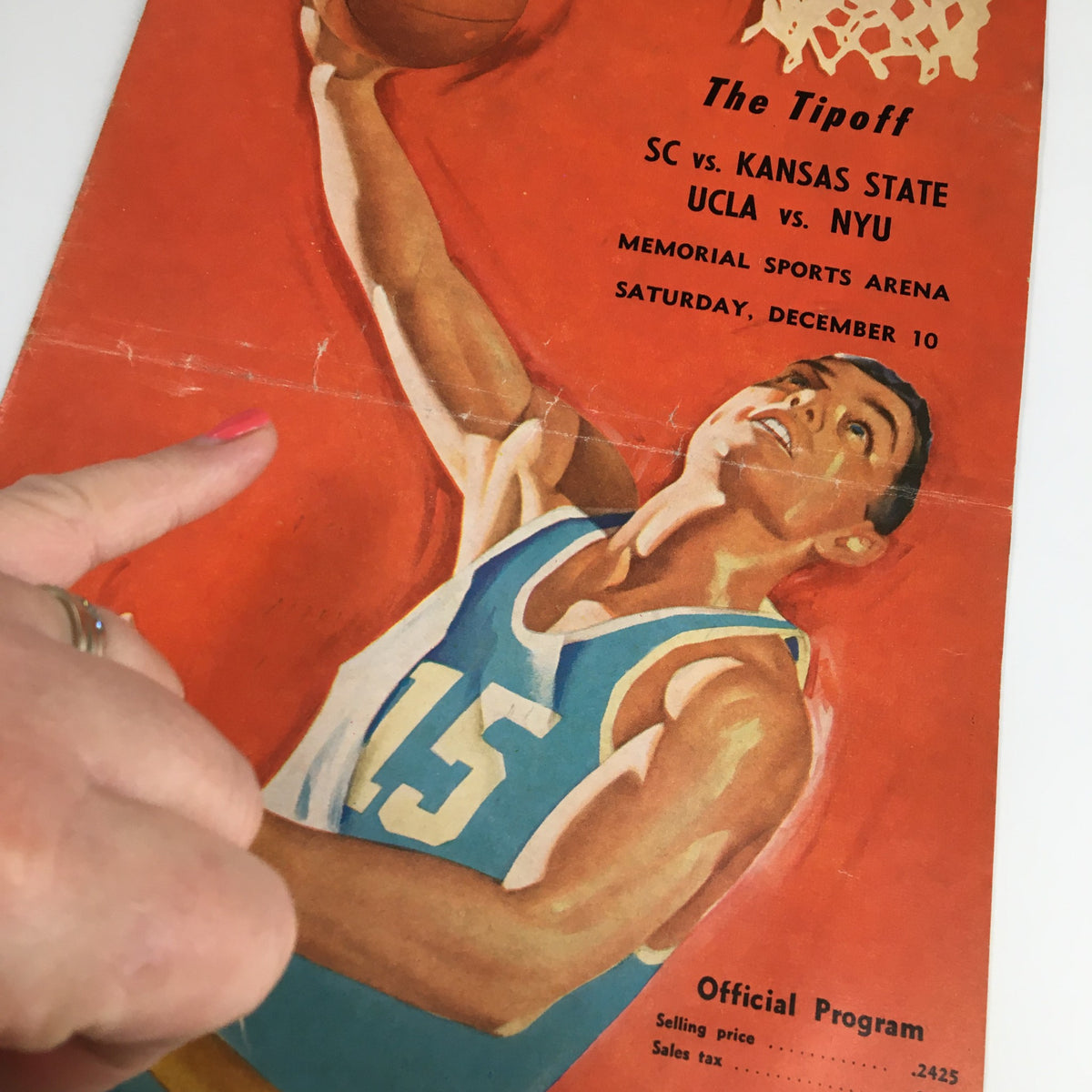 Close-up of the cover of the December 10, 1961 NCAA Basketball UCLA vs NYU The Tipoff Official Program highlighting player number 15.