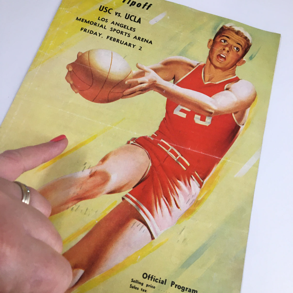 Cover of the February 2, 1960 NCAA Basketball USC vs UCLA Official Program featuring a player in red uniform and action shot.