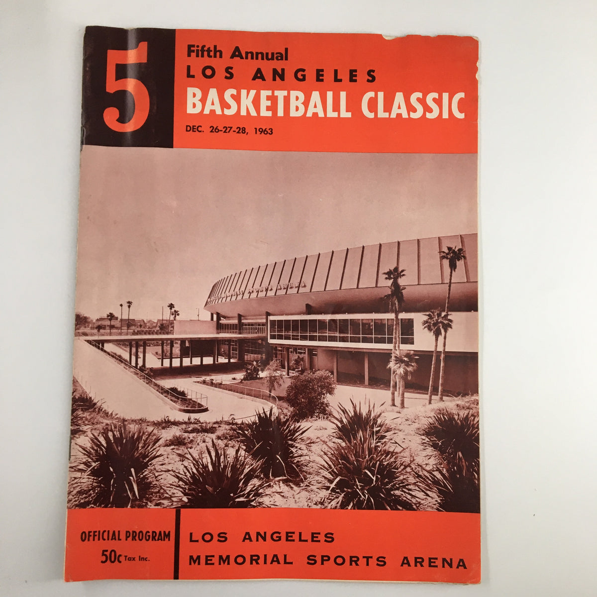 Official program cover of the December 26, 1963 NCAA USC vs UCLA Basketball Classic, showcasing a photograph of the Los Angeles Memorial Sports Arena with a vintage design featuring palm trees and bold typography.