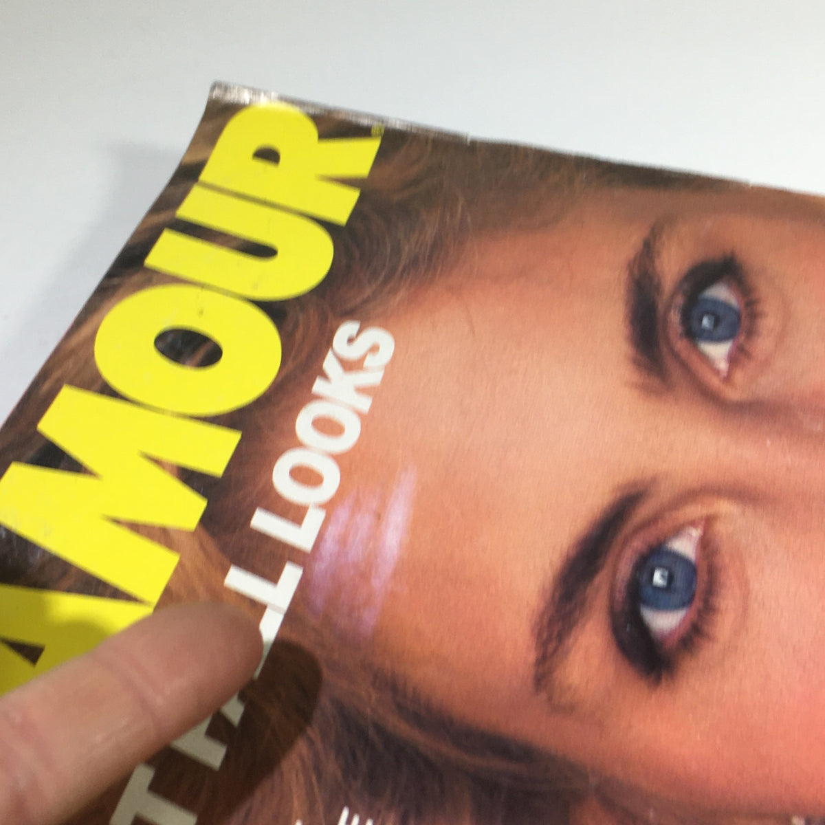 Close-up of the cover of VTG Glamour Magazine: August 1982 highlighting the title 'Glamour' and the phrase 'Great Fall Looks', with a woman's face prominently featured, showing striking blue eyes and well-groomed hair.