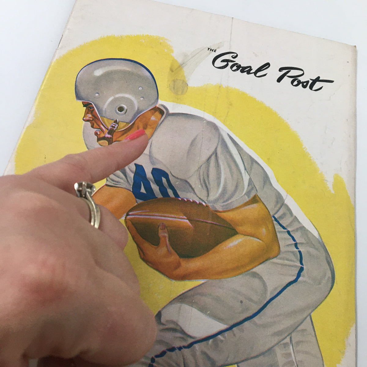 Close-up of the cover of September 16 1955 NCAA Football The Goal Post with a hand pointed at the player illustration.