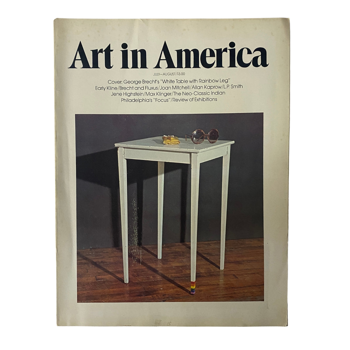 Art in America Magazine July 1974 featuring the cover art 'White Table with Rainbow Leg' by George Brecht, showcasing a minimalist table design against a dark background with subtle lighting effects.