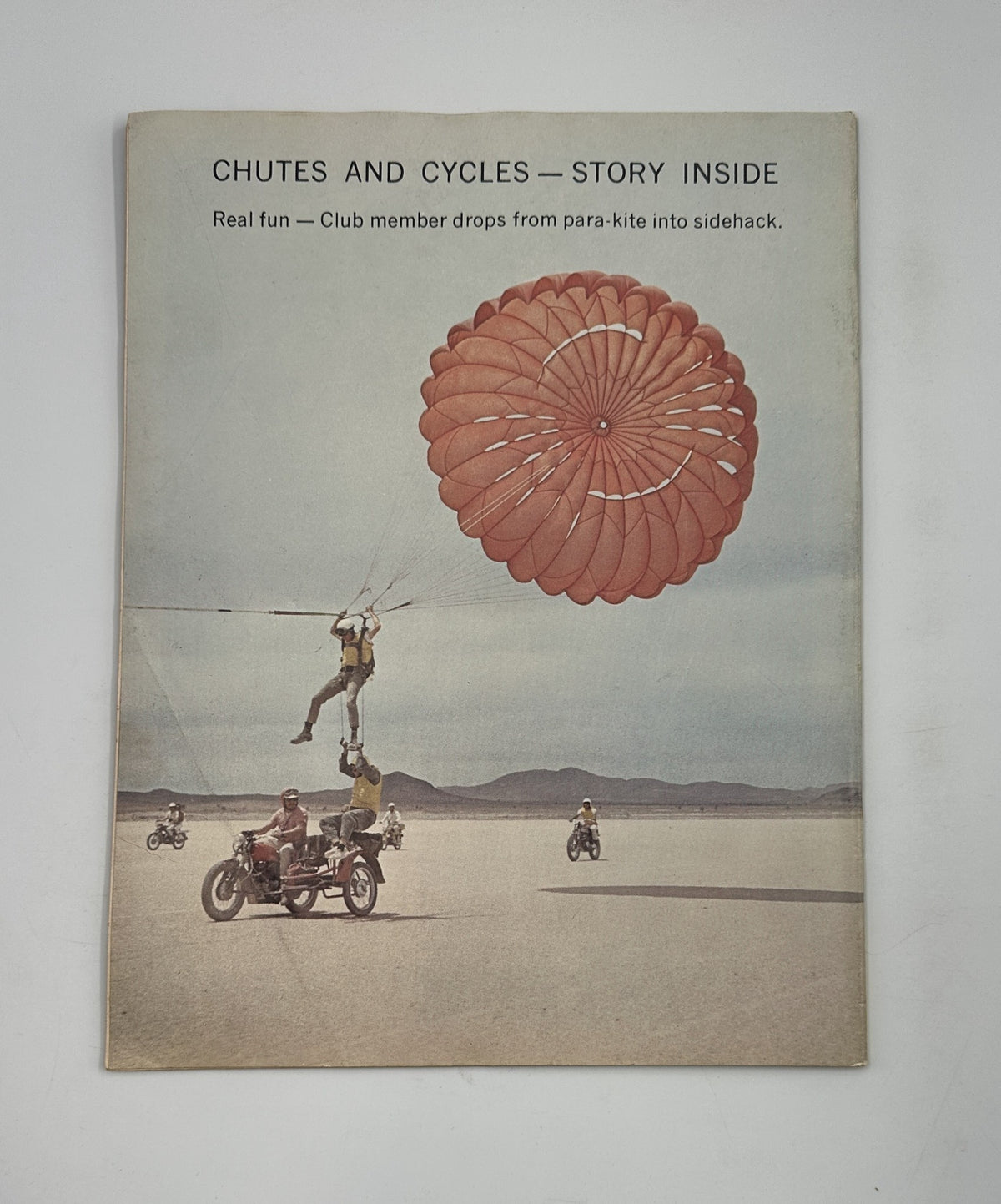 Back cover of Cycle Magazine September 1964 highlighting the story 'Chutes and Cycles' with a dramatic image of a club member parachuting into a sidehack.