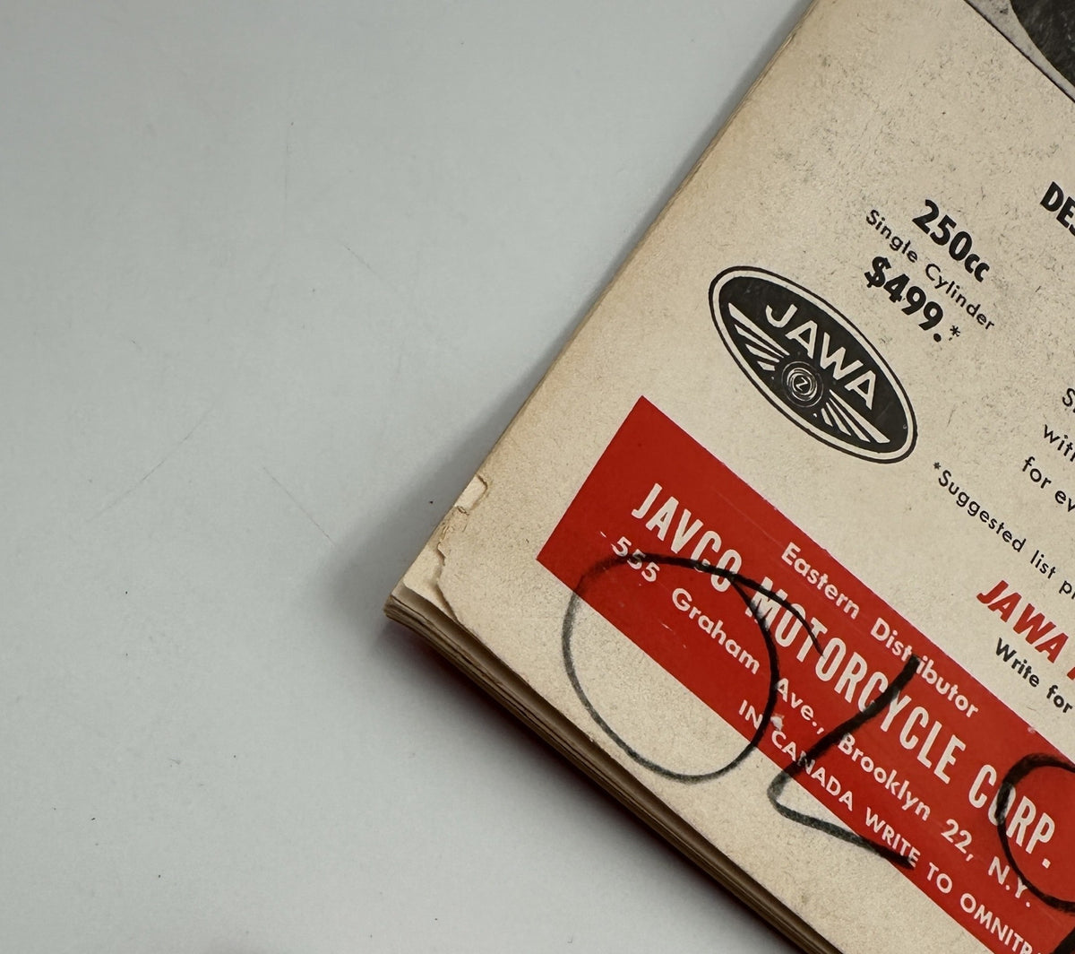 Close-up of the back cover of Cycle Magazine December 1960, featuring an advertisement for JAWA motorcycles, showing signs of wear.